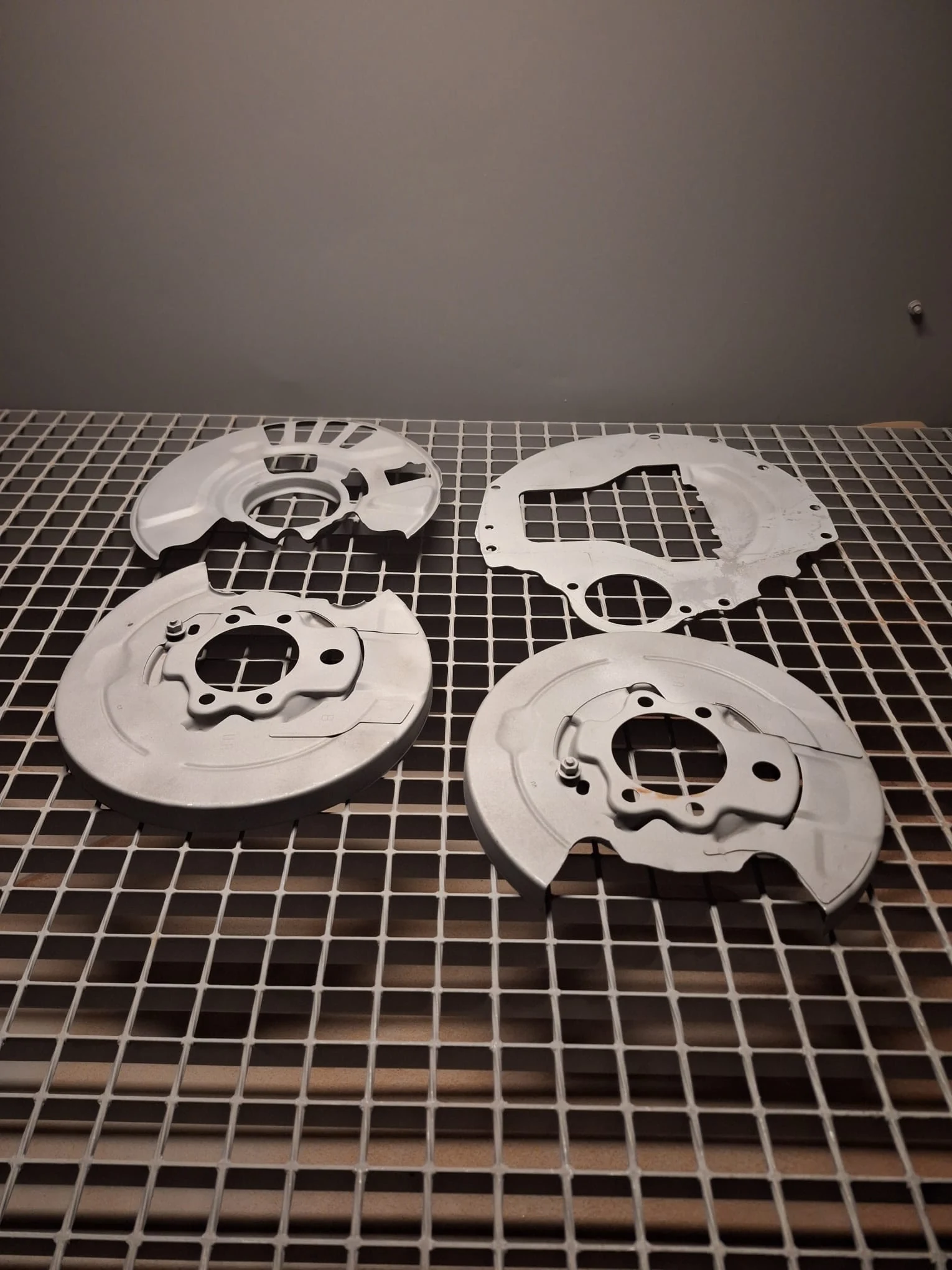 Pièces métalliques préparées par aérogommage sur la grille de la cabine